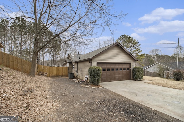 view of side of home with central air condition unit and a garage