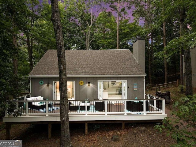 rear view of property featuring a wooden deck