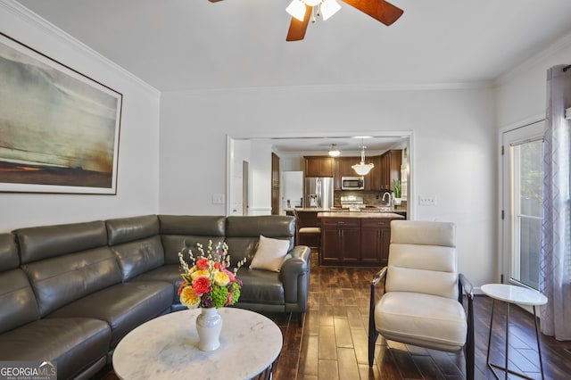 living room with ornamental molding and ceiling fan