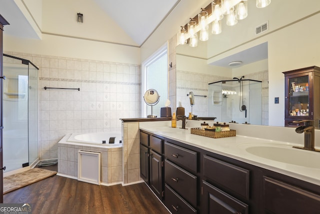 bathroom with lofted ceiling, vanity, hardwood / wood-style flooring, and plus walk in shower