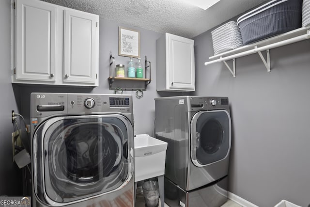 laundry area featuring cabinets, sink, washing machine and clothes dryer, and a textured ceiling