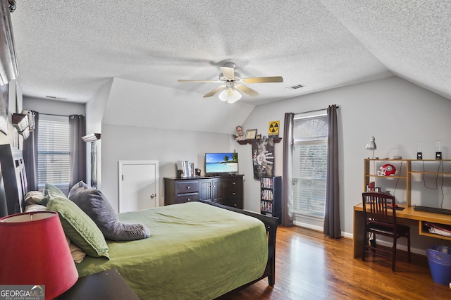 bedroom featuring lofted ceiling, dark hardwood / wood-style floors, a textured ceiling, and ceiling fan