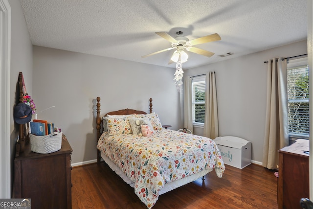 bedroom featuring a textured ceiling, dark hardwood / wood-style floors, and ceiling fan