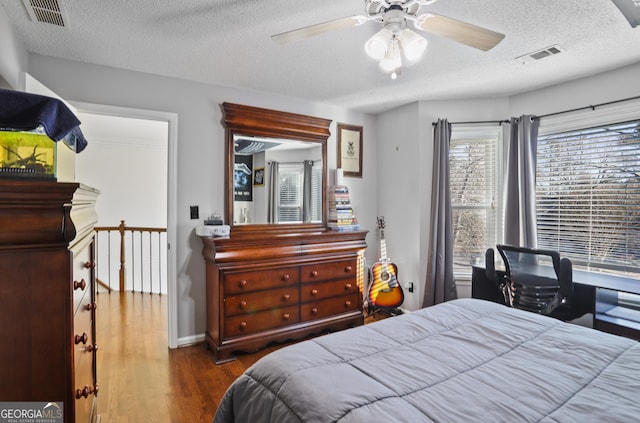 bedroom featuring a textured ceiling, ceiling fan, and hardwood / wood-style flooring