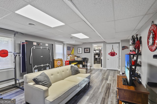 living room with hardwood / wood-style flooring and a paneled ceiling