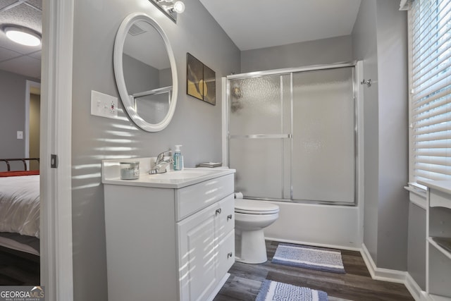 full bathroom with enclosed tub / shower combo, vanity, toilet, and hardwood / wood-style floors