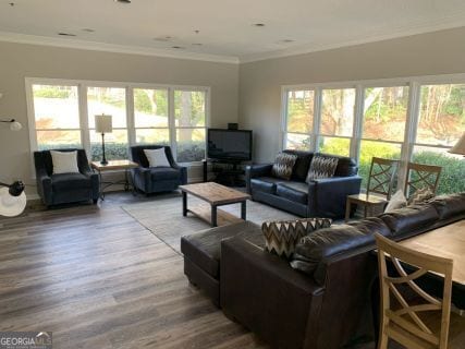 living room with crown molding, a healthy amount of sunlight, and wood-type flooring