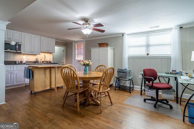 dining space with ceiling fan, hardwood / wood-style floors, and crown molding