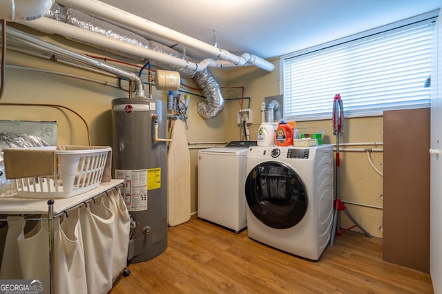 laundry room featuring water heater, light hardwood / wood-style flooring, and washer and clothes dryer