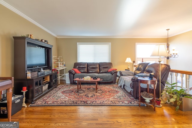 living room with hardwood / wood-style flooring, a chandelier, and ornamental molding