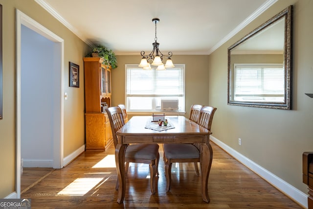 dining area with a notable chandelier, hardwood / wood-style flooring, ornamental molding, and plenty of natural light