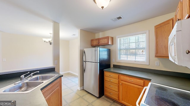 kitchen with sink, stove, and stainless steel fridge