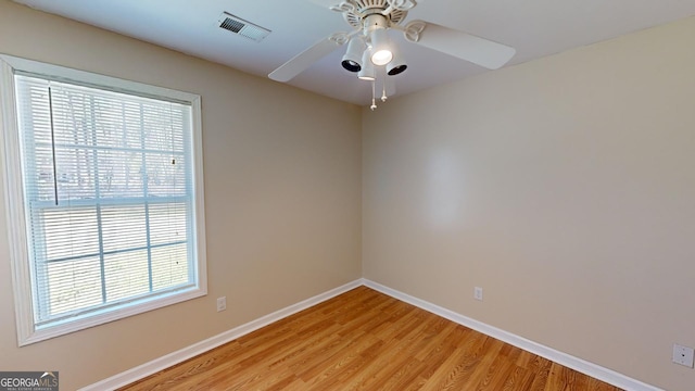 spare room featuring a healthy amount of sunlight, light hardwood / wood-style flooring, and ceiling fan