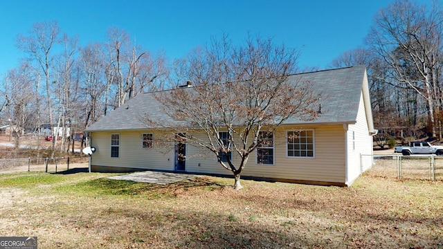 rear view of house with a lawn and a patio