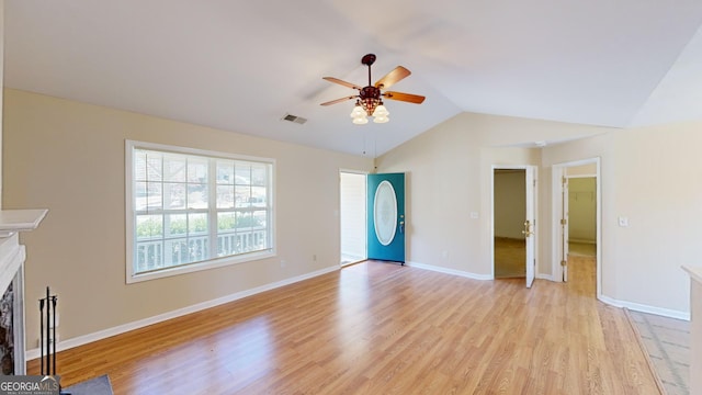 unfurnished living room with ceiling fan, lofted ceiling, and light wood-type flooring