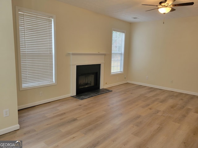 unfurnished living room featuring ceiling fan and light hardwood / wood-style floors