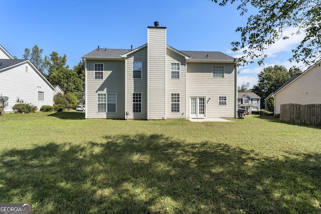 rear view of property with a yard