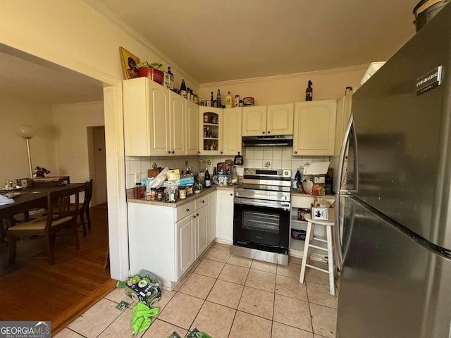 kitchen with white cabinets, refrigerator, light tile patterned floors, and stainless steel electric range