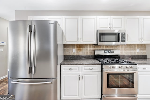 kitchen with white cabinetry, backsplash, dark hardwood / wood-style floors, and appliances with stainless steel finishes