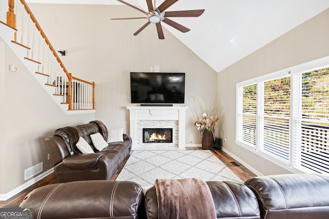 living room featuring ceiling fan, high vaulted ceiling, hardwood / wood-style floors, and a fireplace