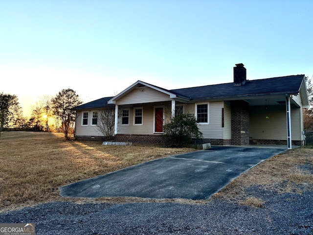 single story home with a lawn and a carport