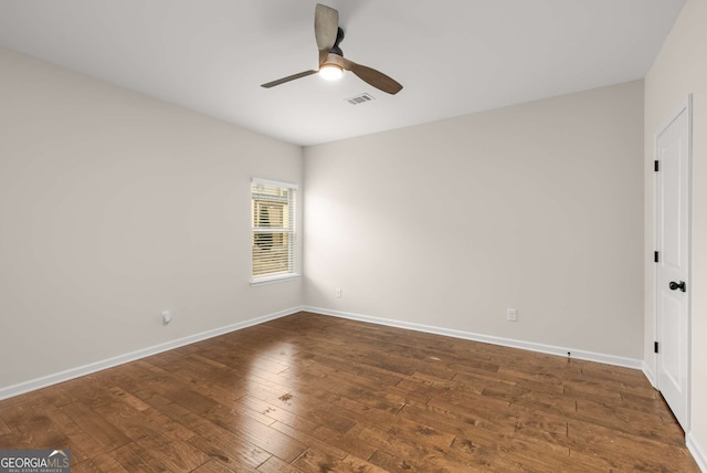 empty room with dark hardwood / wood-style floors and ceiling fan