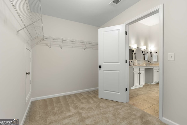 spacious closet featuring light carpet and sink