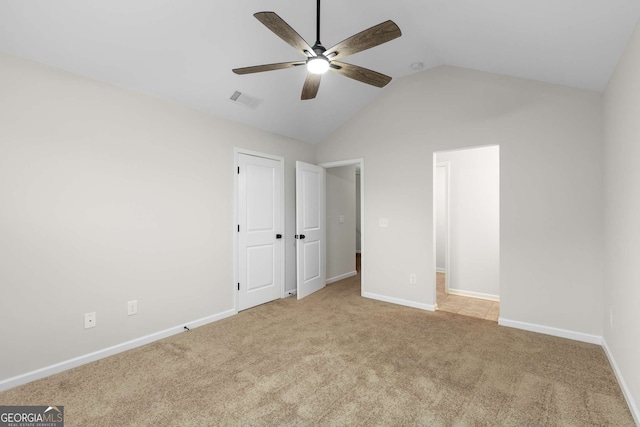 unfurnished bedroom featuring vaulted ceiling, light carpet, and ceiling fan