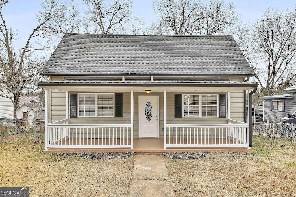 bungalow with covered porch and a front yard