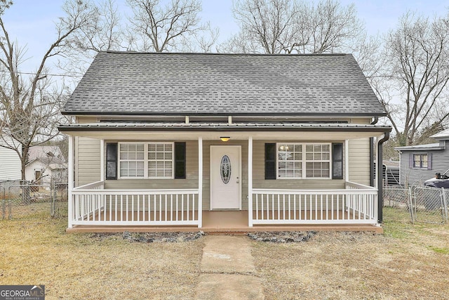 bungalow with covered porch and a front yard