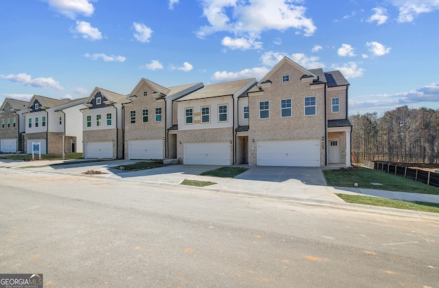 view of property with brick siding, fence, a garage, a residential view, and driveway