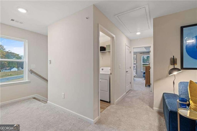 hallway featuring attic access, washer / clothes dryer, visible vents, and carpet floors