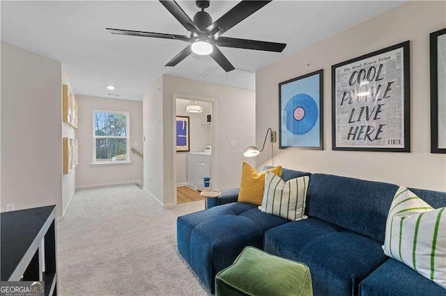 carpeted living room with washing machine and dryer, ceiling fan, and baseboards