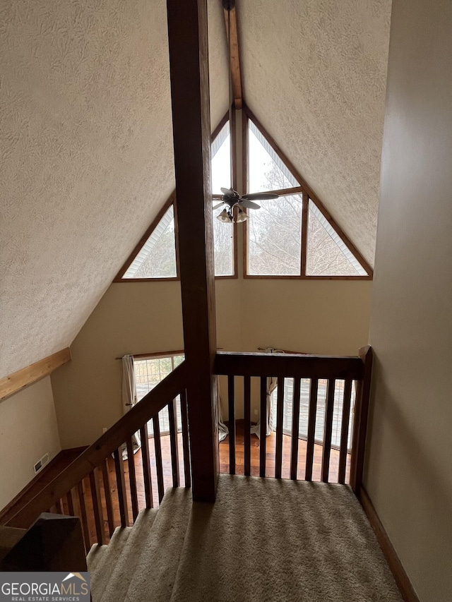 staircase with lofted ceiling with beams, carpet floors, a textured ceiling, and ceiling fan