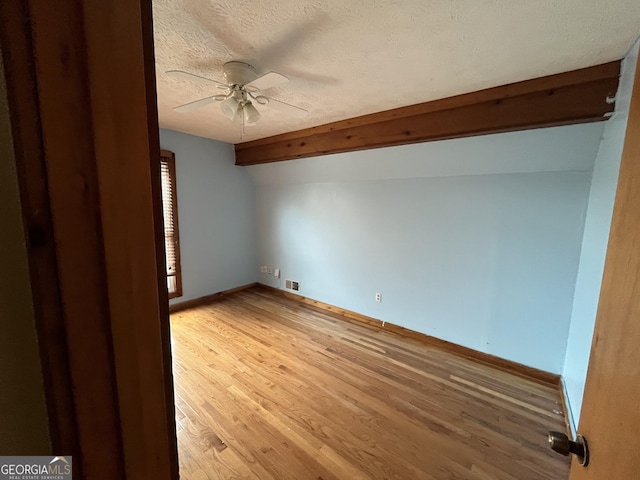 spare room with hardwood / wood-style flooring, ceiling fan, a textured ceiling, and lofted ceiling