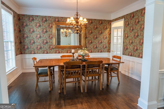 dining space with crown molding, dark wood-type flooring, and an inviting chandelier