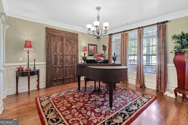 misc room with a notable chandelier, crown molding, and wood-type flooring