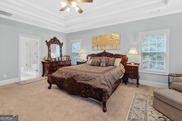 bedroom with light colored carpet, a tray ceiling, and multiple windows