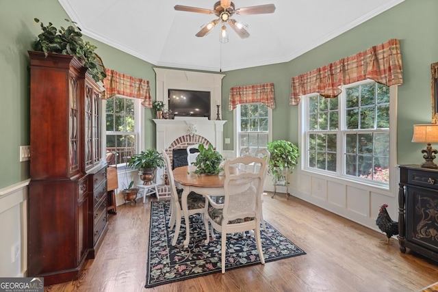 dining space featuring crown molding, a fireplace, and a wealth of natural light