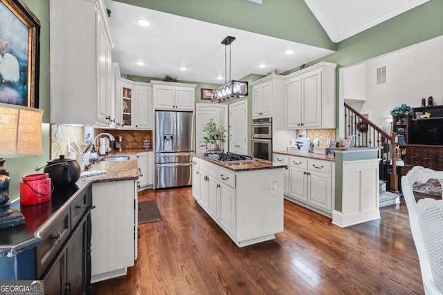 kitchen featuring sink, white cabinets, hanging light fixtures, a center island, and stainless steel appliances