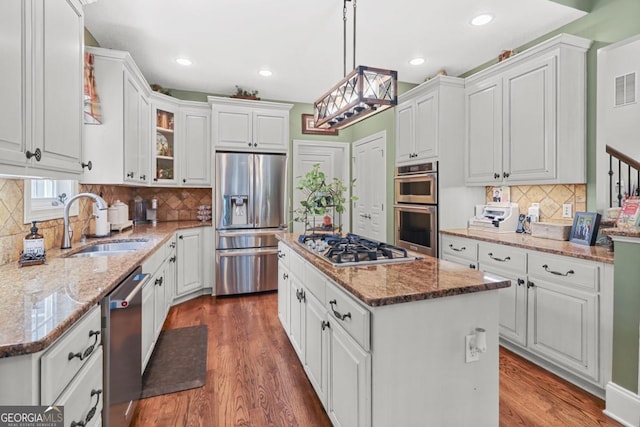 kitchen featuring stainless steel appliances, a center island, and white cabinets