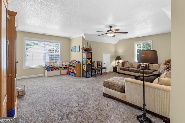 carpeted living room with ceiling fan, vaulted ceiling, and a textured ceiling