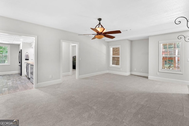 interior space featuring ceiling fan and light colored carpet