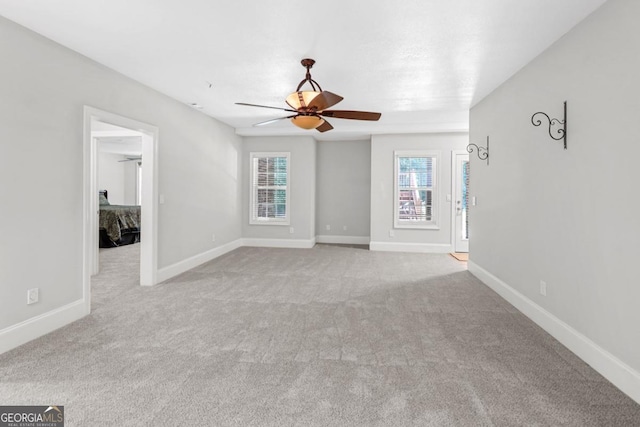 spare room with ceiling fan and light carpet