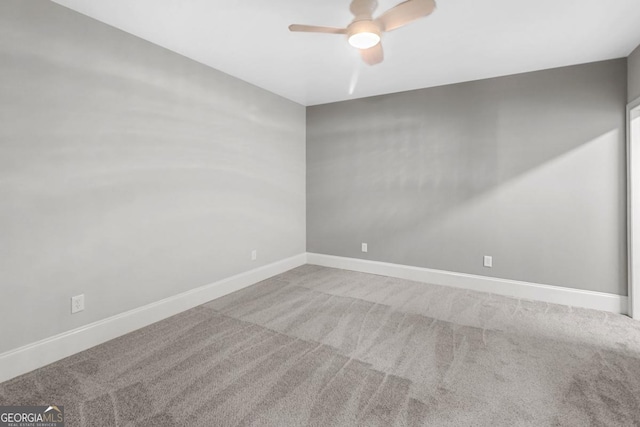 carpeted spare room with ceiling fan