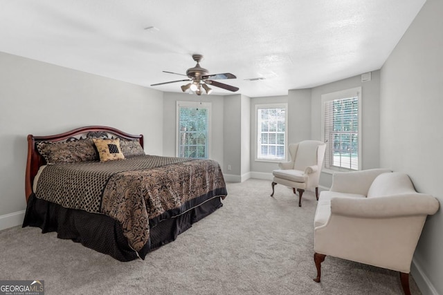 carpeted bedroom with ceiling fan and a textured ceiling