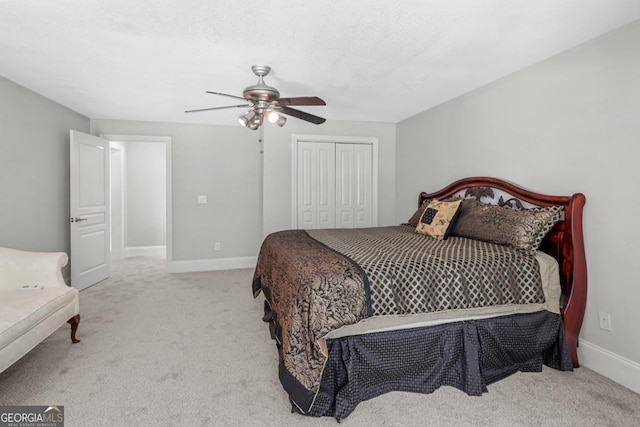 carpeted bedroom with a textured ceiling, a closet, and ceiling fan