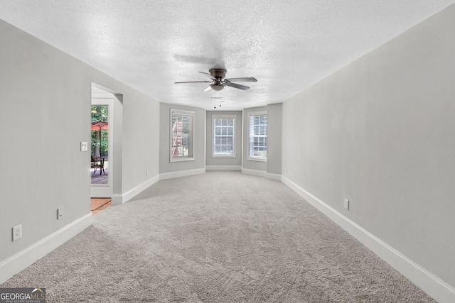 carpeted empty room with a textured ceiling and ceiling fan