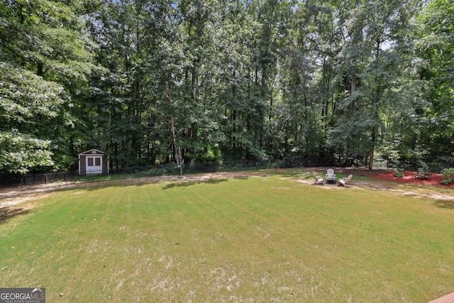 view of yard with a storage shed and a fire pit