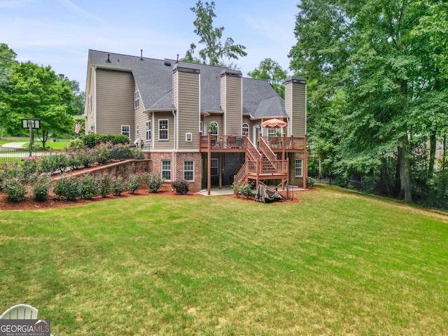 rear view of house featuring a yard and a deck